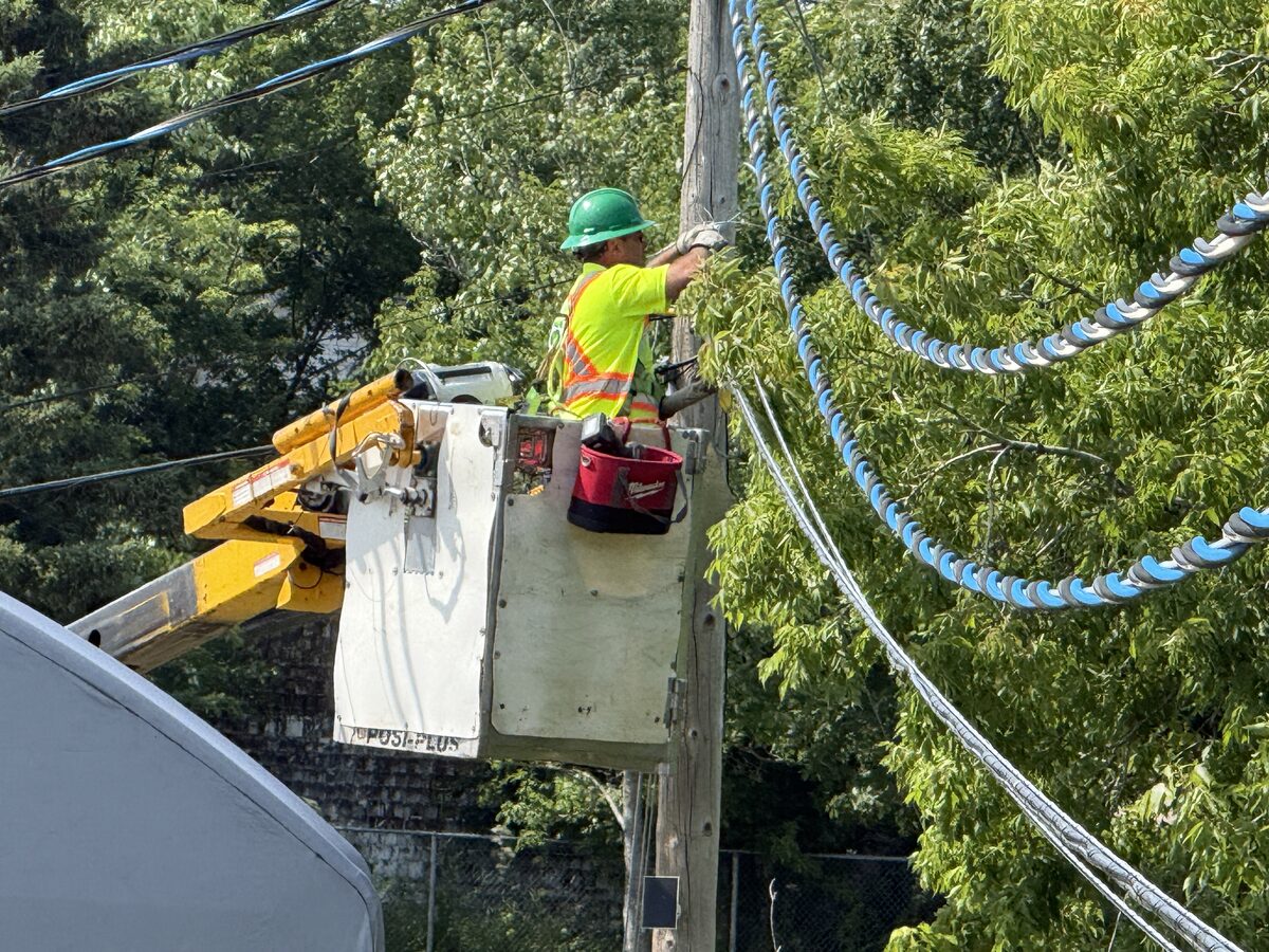 Tinuum lineman working aerial fibre from a bucket truck, New Brunswick